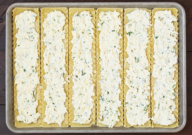 Lasagna Roll Ups. Not only look incredible but taste incredible. There's served in individual portions and are great for freezing too. | Lasagna Recipes | Easy Lasagna | #cookingclassy #lasagna #pasta #rollups Ricotta cheese spread on lasagna roll ups in a baking tray