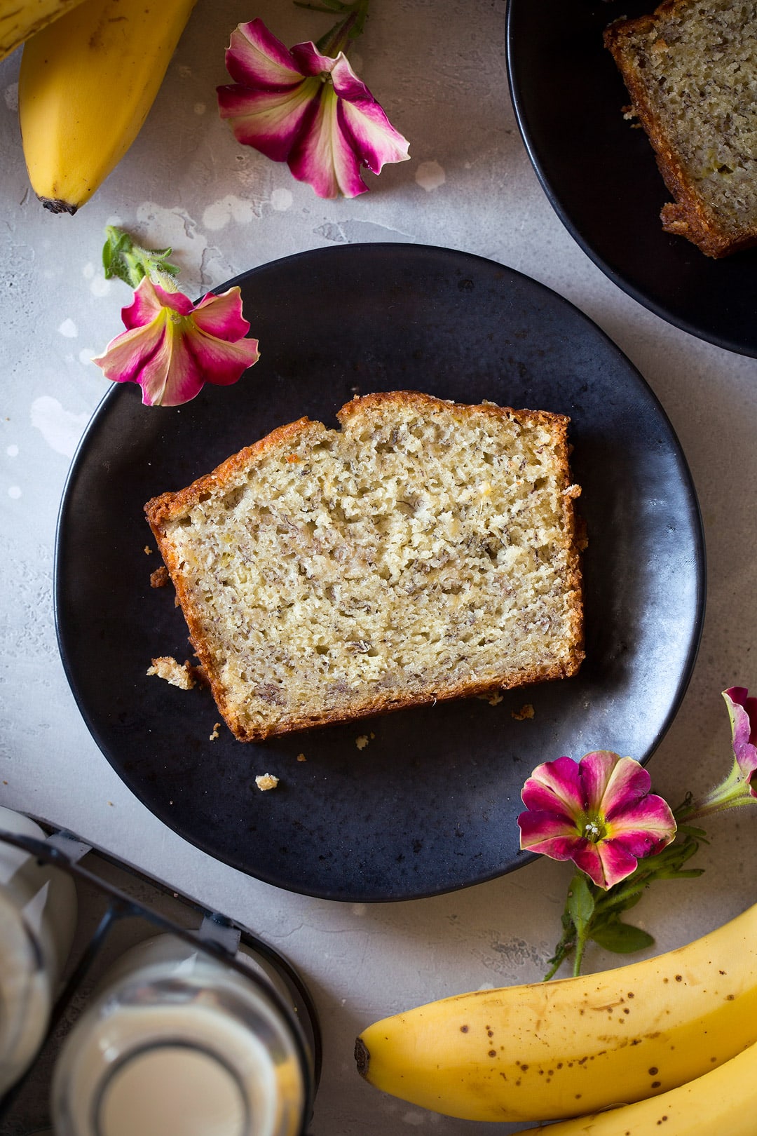 This is the best banana bread recipe! Quick and easy to make and no mixer is required. It's perfectly moist and amazingly tender and it's brimming with banana flavor. Simply put, everyone will have a hard time stopping at just one slice! #cookingclassy #banana #bread #bananabread individual slice of banana bread on small plate