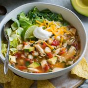 Chicken Pozole in a single serve bowl set over a plate.