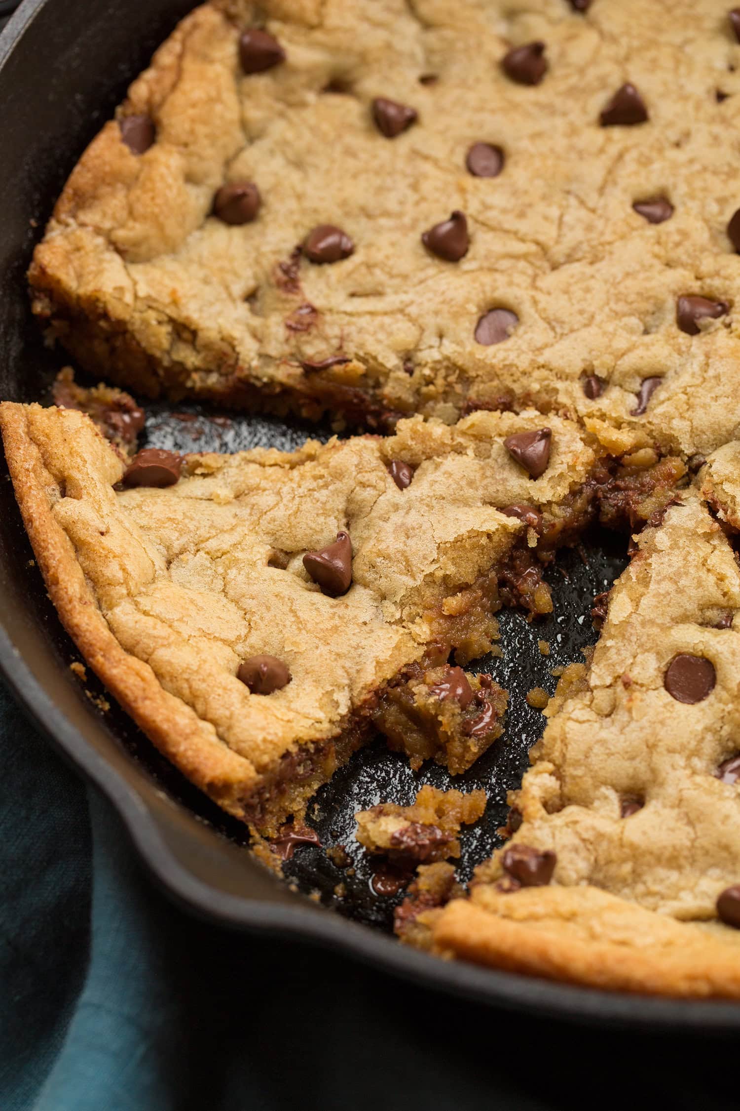 Skillet Chocolate Chip Cookie Close up photo showing soft slightly gooey texture of skillet chocolate chip cookie cut into.