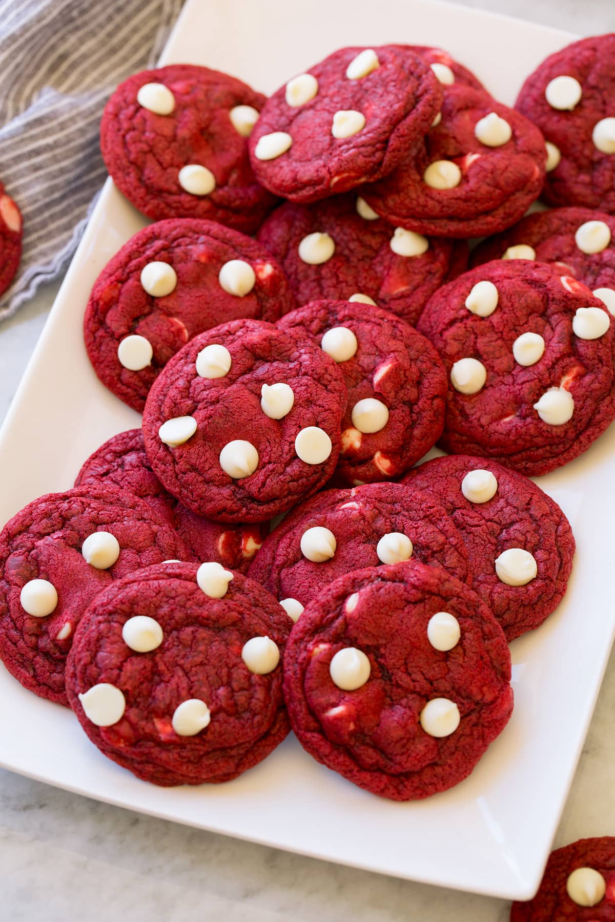 Red Velvet Cookies Red Velvet Cookies layered together, shown from a side angle on a platter.