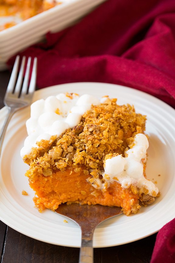 Browned Butter Sweet Potato Casserole Single serving of sweet potato casserole being scooped onto a white serving plate.