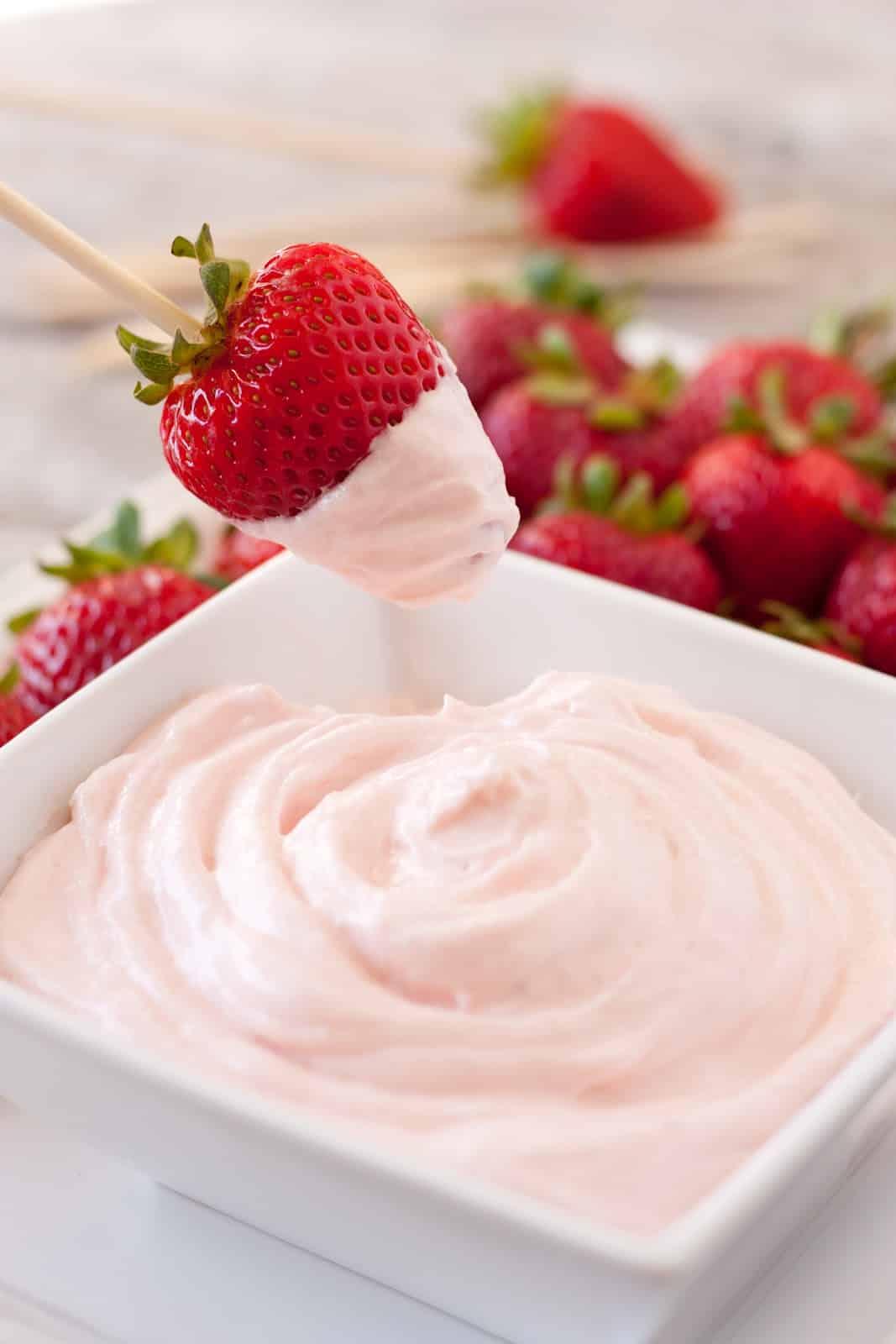 Fruit Dip Recipe Fruit Dip in a serving bowl with strawberry dipped in a skewer.