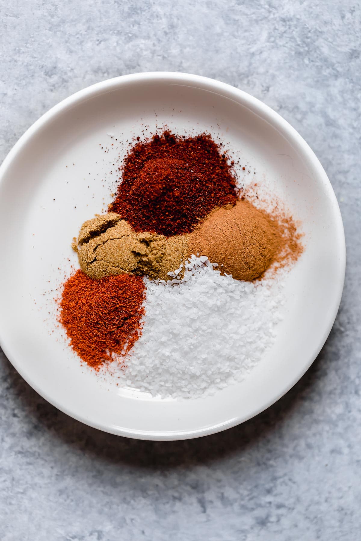 Island Pork Tenderloin Pork tenderloin rub spices in sections on a white plate.