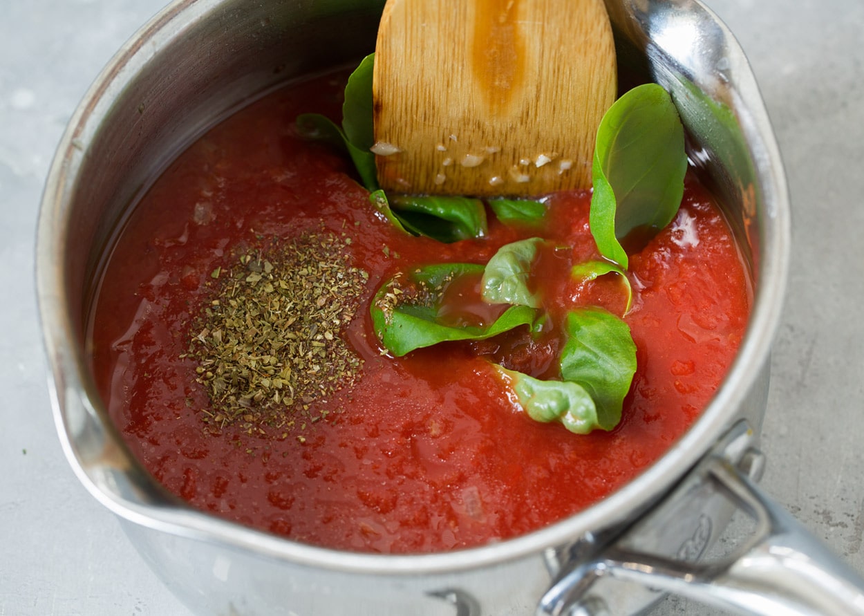 BEST Chicken Parmesan recipe! Showing how to make marinara sauce in a stainless steel saucepan for chicken parmesan.