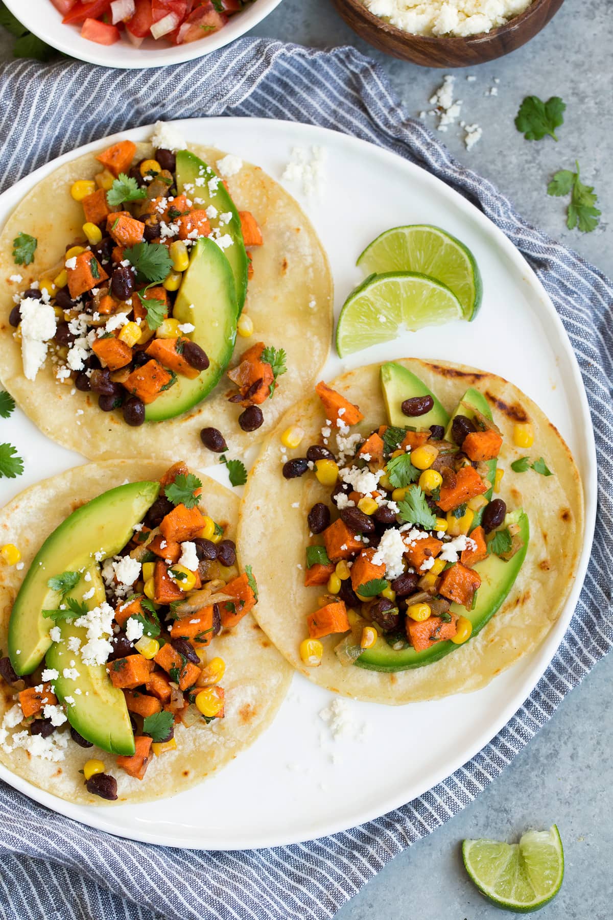 Sweet Potato and Black Bean Tacos Three healthy sweet potato and black bean tacos on white plate.