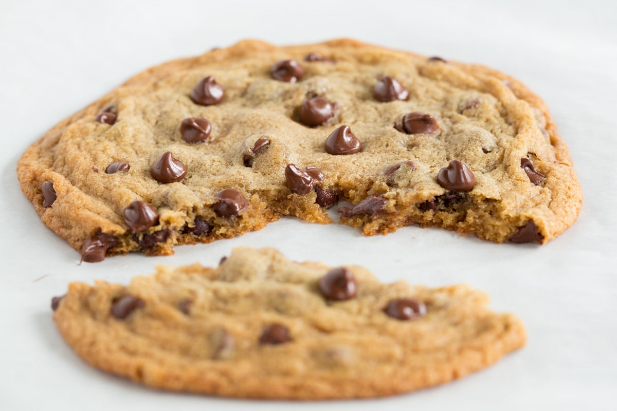 One Single Chocolate Chip Cookie Chocolate chip cookie with a portion broken off to show texture of interior of cookie.