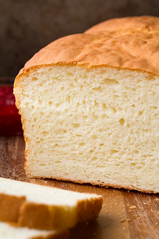 Gluten-Free White Bread | Cooking Classy Gluten Free Bread shown here on a wood cutting board up close with two slices cut