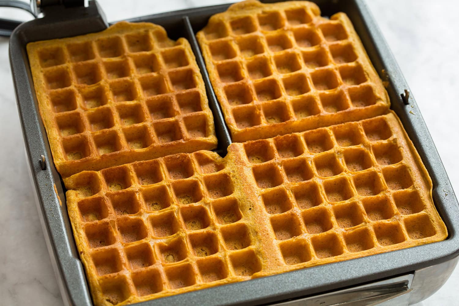 Pumpkin Waffles Completed pumpkin waffles in a waffle iron.