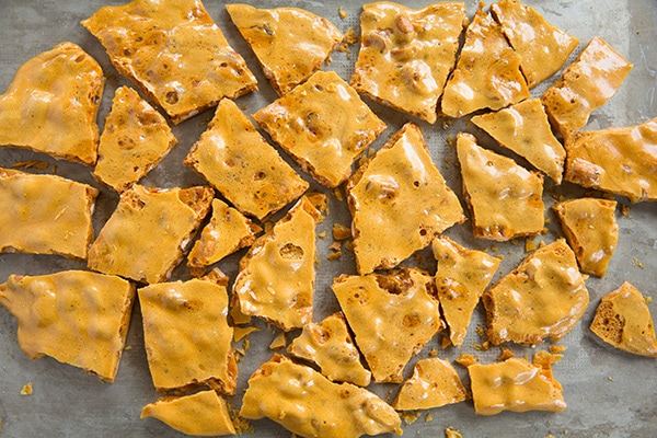 Peanut Brittle Breaking peanut brittle into pieces after cooling.