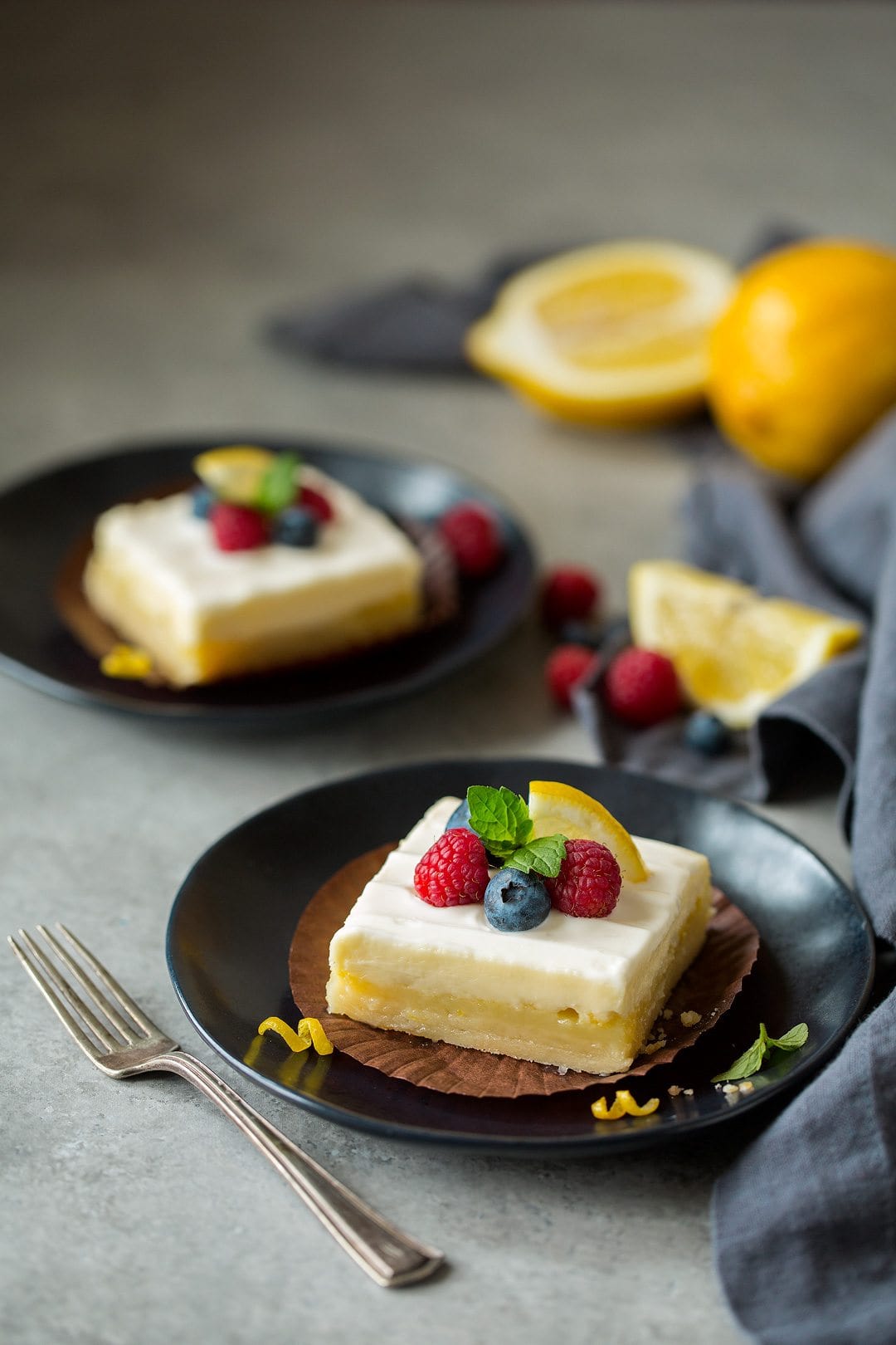 two slices of Lemon Cheesecake Bars on plates