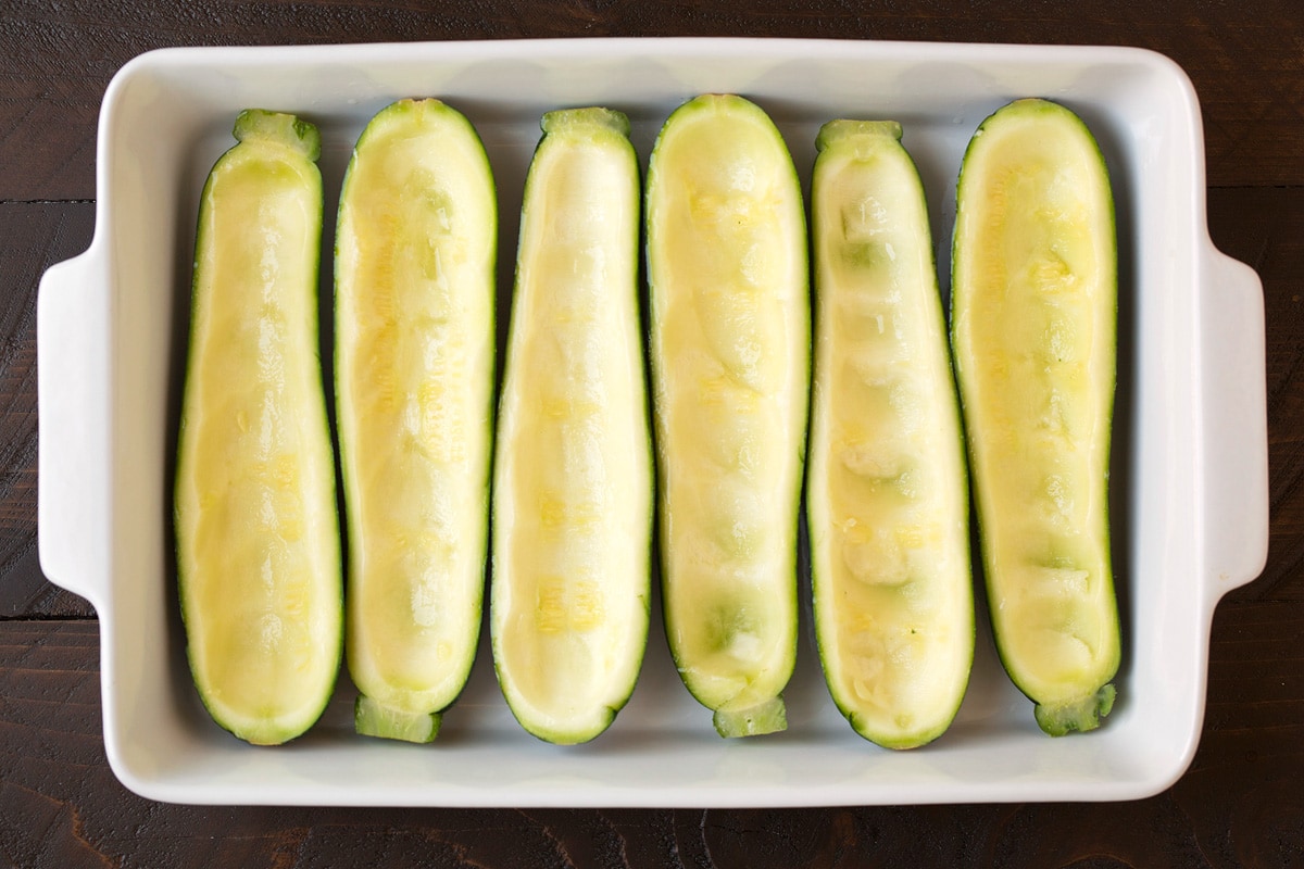 Lasagna Zucchini Boats Hollowed out zucchini made into boats in a baking dish before adding filling.
