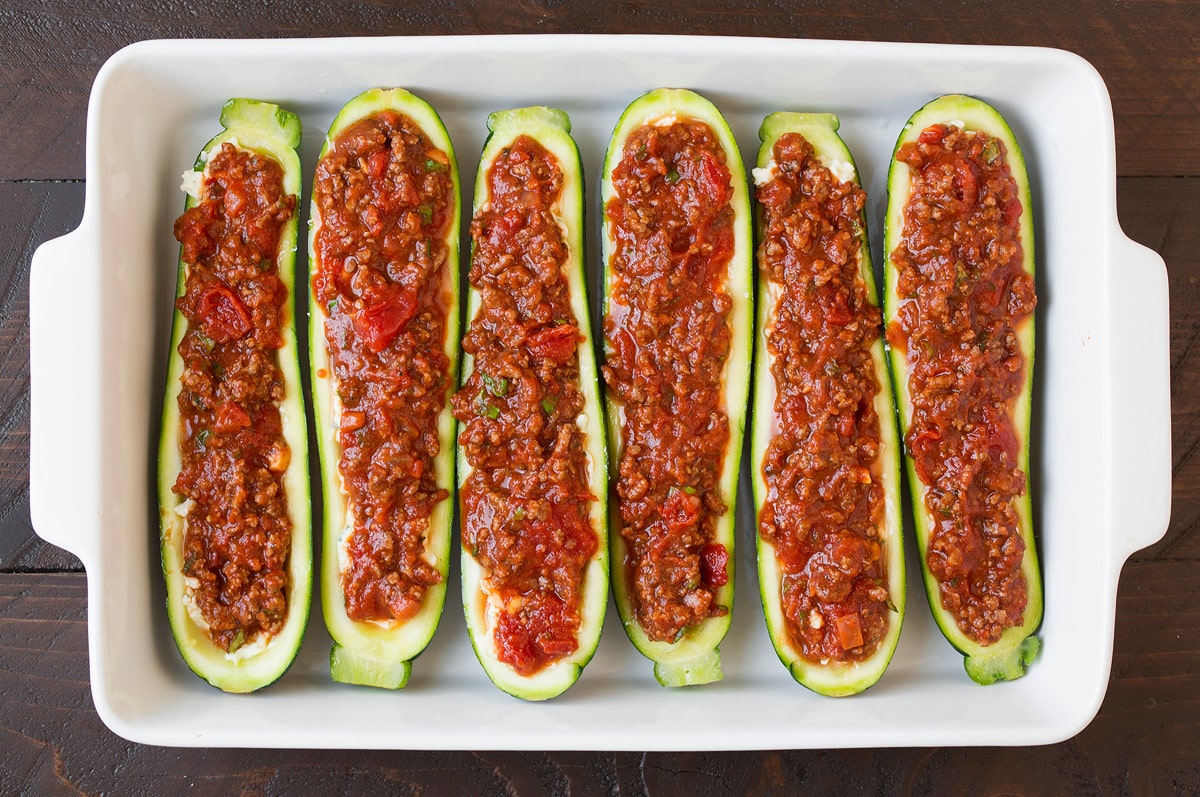 Lasagna Zucchini Boats Adding sauce layer to zucchini boats.