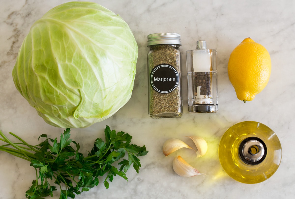 Roasted Cabbage Photo: Ingredients used in making roasted cabbage are shown here. Includes fresh cabbage, olive oil, garlic, parsley, lemon, salt, pepper, and marjarom.