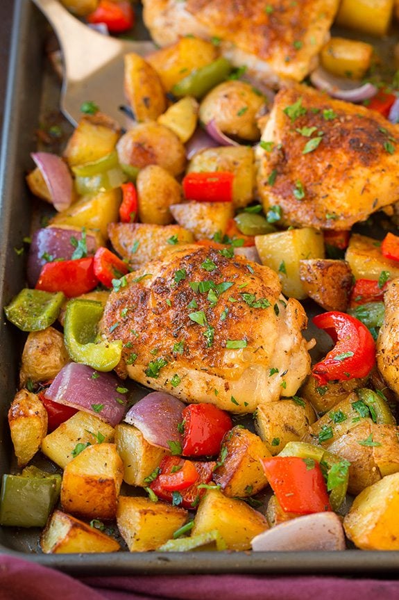 One Pan Cajun chicken and Veggies Baked cajun chicken thighs and veggies with cajun seasoning on a sheet pan.
