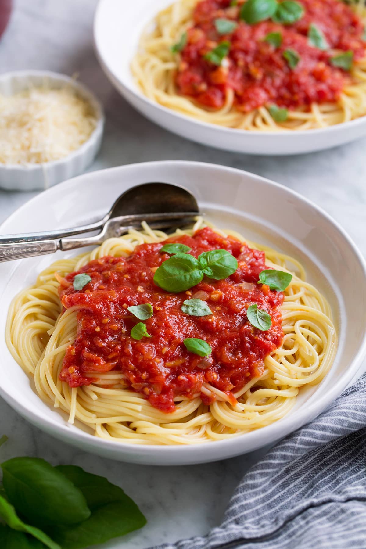 Homemade Marinara Sauce - so much better than the bottled stuff! This is authentic, fresh tasting sauce that you'll want to make again and again! Perfect over just about any type of pasta or served with cheese tortellini. It freezes really well too! #marinara #sauce #recipe #italianfood #dinner #lunch Mound of marinara sauce over spaghetti