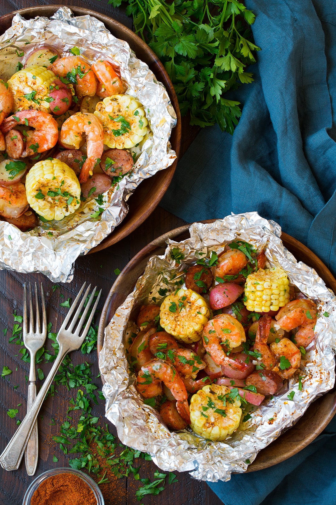 two Shrimp foil Packets on plates with fresh cilantro