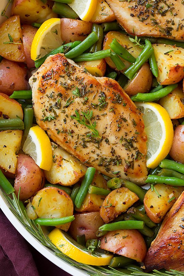 Garlic Herb Chicken and Veggies Garlic and herb seasoned chicken breasts in a skillet with green beans, potatoes and lemons.