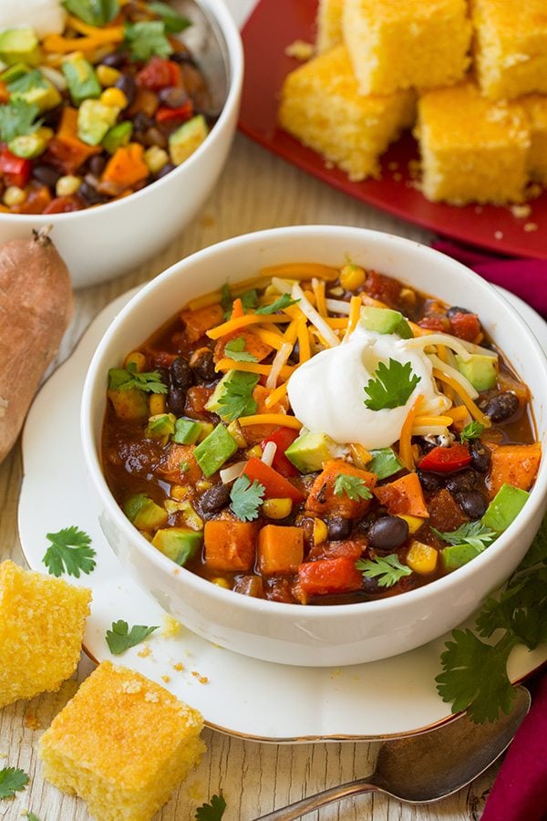 Sweet Potato and Black Bean Chili Sweet potato chili in a serving bowl garnished with avocado, cheese, sour cream and cilantro.