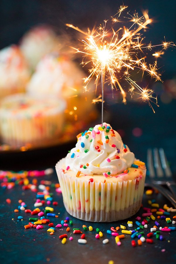 Funfetti Mini Cheesecakes Mini birthday cheesecake with sparkler lit resting in it.