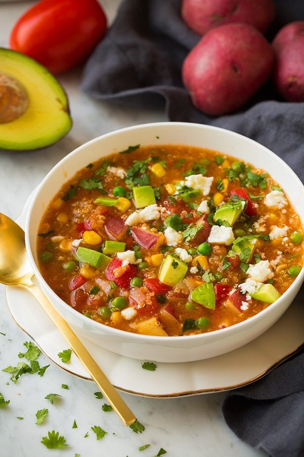 Quinoa and Vegetable Stew Quinoa and Vegetable Stew in a white bowl set over a gold rimmed white plate.