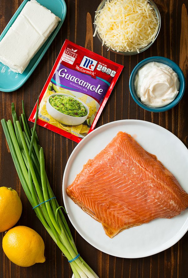 Smoked Salmon Dip Ingredients needed for smoked salmon dip shown here. Includes cream cheese, mayonnaise, greek yogurt, white cheddar, green onions, lemons, seasoning, smoked salmon.