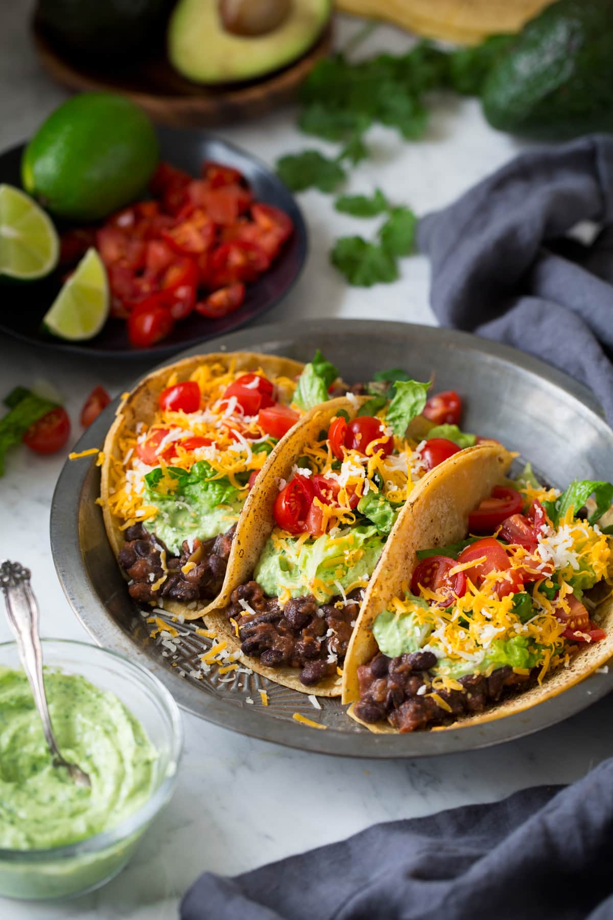 Black Bean Tacos with Cilantro Lime Crema Three black bean tacos in a pie dish