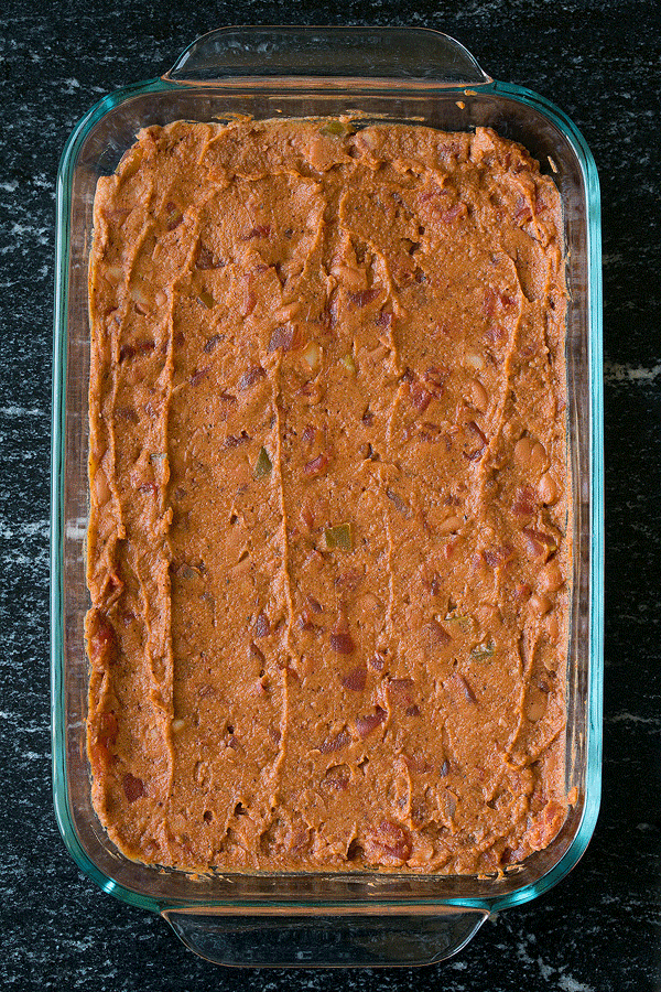 The BEST 7 Layer Dip! Made with seasoned refried beans, guacamole, sour cream, cheese, olives, tomatoes and green onions. A family favorite recipe! | Easy Dips | Party Food | #cookingclassy #dip #beans #appetizers A GIF image showing layers of a 7-layer bean dip