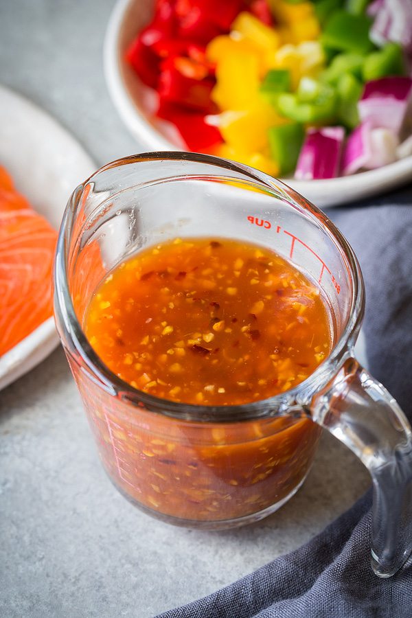 Sweet and Sour Salmon Measuring Glass filled with homemade Sweet and Sour Sauce