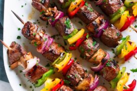 Grilled Steak Kebabs on an oval white platter.