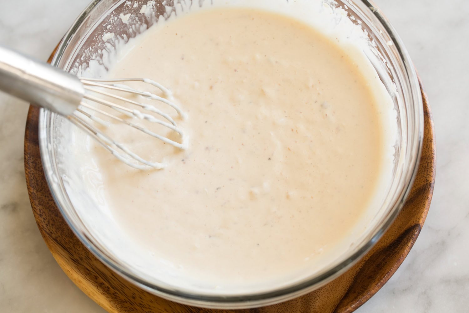 Chicken Caesar Pasta Salad Chicken caesar salad dressing shown after mixing ingredients.