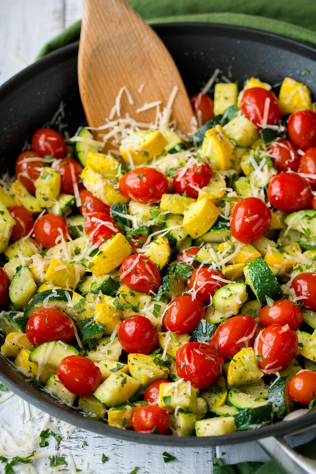 Garlic Parmesan Zucchini, Squash and Tomatoes sauteed zucchini and squash with tomatoes in a large black skillet.