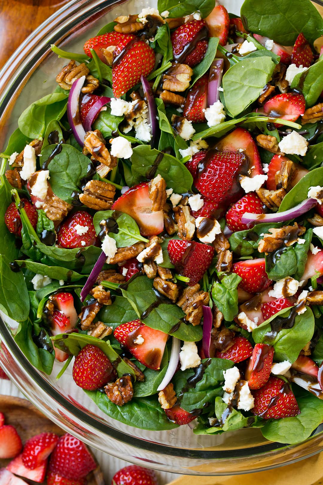 Strawberry Spinach Salad. An easy and delicious spinach salad made with strawberries, feta, candied pecans and a balsamic vinaigrette. | Strawberry Salad | Summer Salads | Easy Salads | #cookingclassy #spinach #strawberry #salad A close up of a Strawberry Spinach Salad drizzled with balsamic