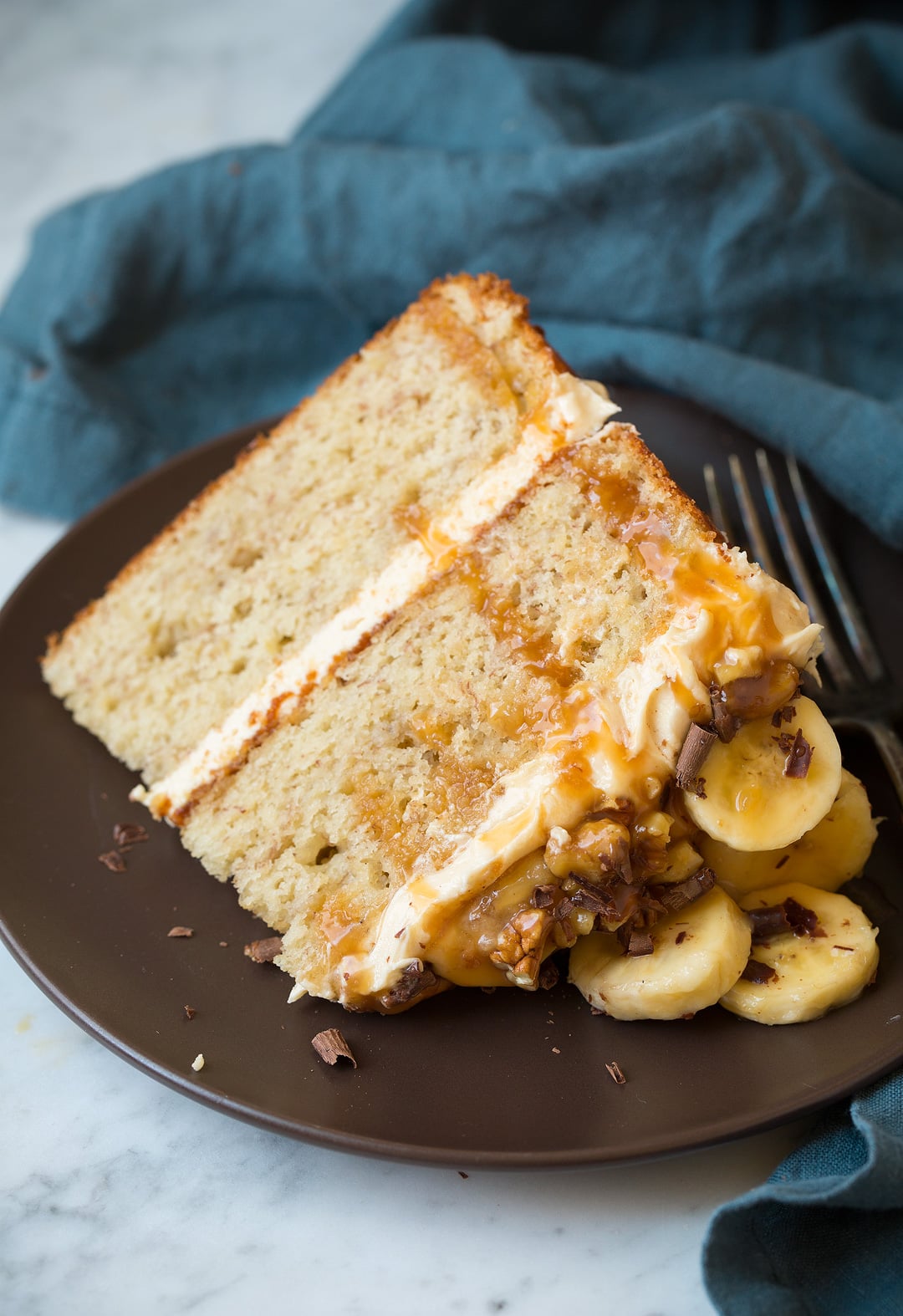 Banana Cake Slice of banana cake on a matte brown plate.