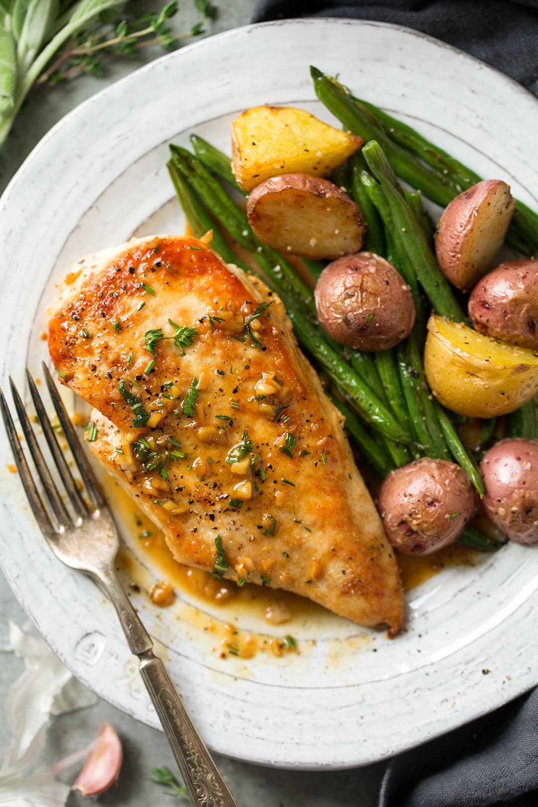 Super quick and easy seared skillet chicken topped with a delicious garlic and herb pan sauce that's sure to please! A perfect chicken recipe for busy weeknights. | Chicken Dinner | Chicken Recipes | Weeknight Meals | #cookingclassy #chicken #sauce #butter Skillet Chicken with Garlic Herb Butter Sauce on a plate with veggies