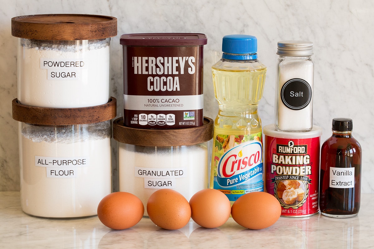 Chocolate Crinkle Cookies Image of ingredients used to make chocolate crinkle cookies. Includes flour, granulated sugar, powdered sugar, eggs, hershey's cocoa, vegetable oil, baking powder, salt and vanilla extract.