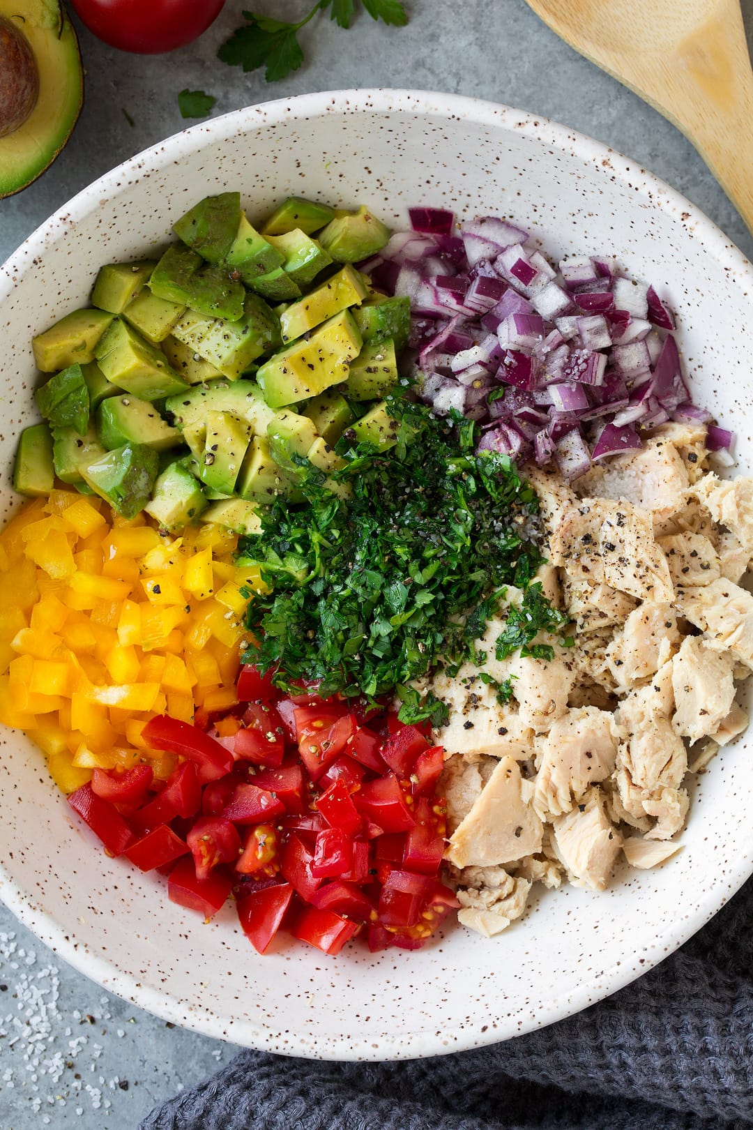 Avocado Tuna Salad mixture shown here. Tuna, avocado, red onion, yellow bell pepper, tomato, parsley, salt, pepper, olive oil.