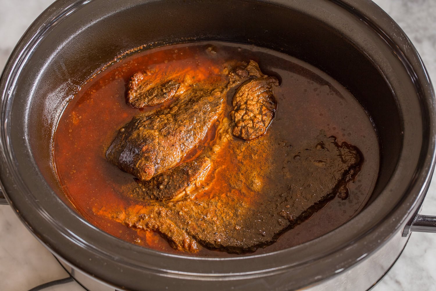 Shredded Beef Tacos Beef chuck roast finished cooking in slow cooker.