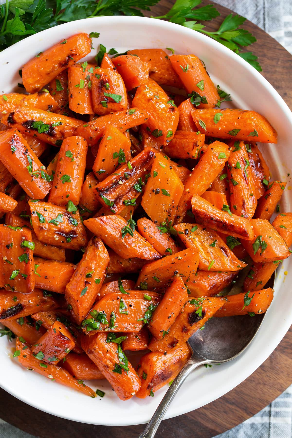 Roasted Carrots Photo: Overhead angle of roasted carrots in a serving bowl set over a wooden platter.