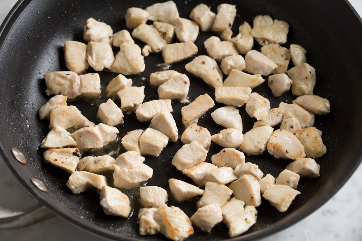 The BEST Chicken Fried Rice Showing how to make chicken fried rice. Sautéing small chicken breast pieces in a skillet until cooked through.