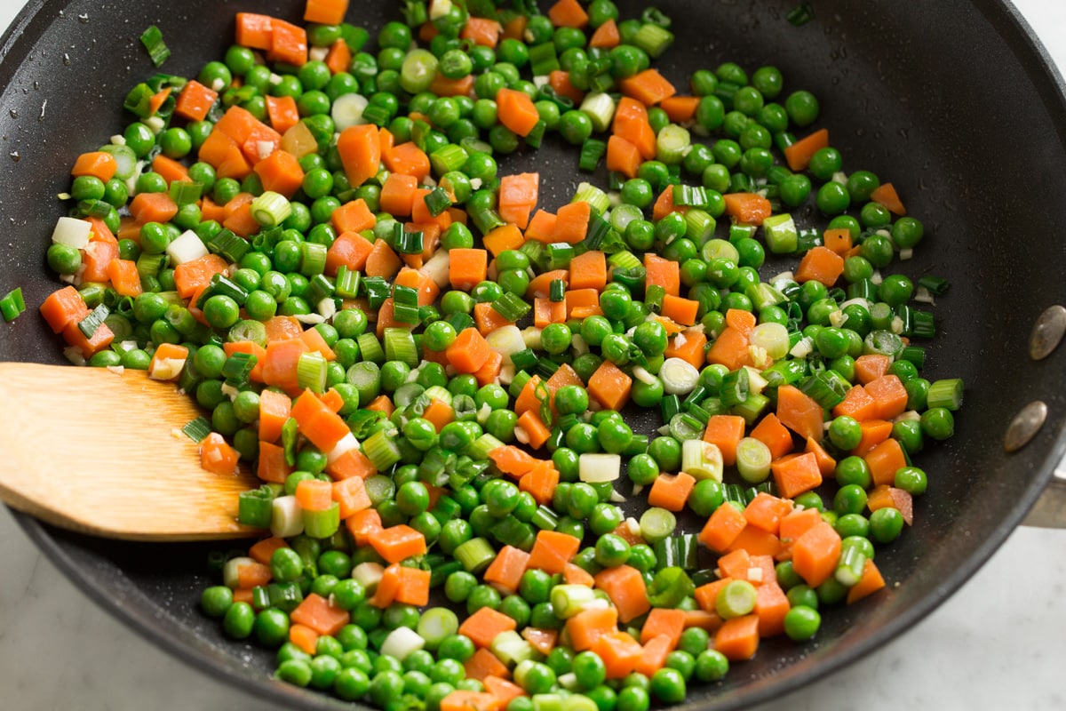 Chicken Fried Rice Sautéing peas and carrots in skillet for fried rice.