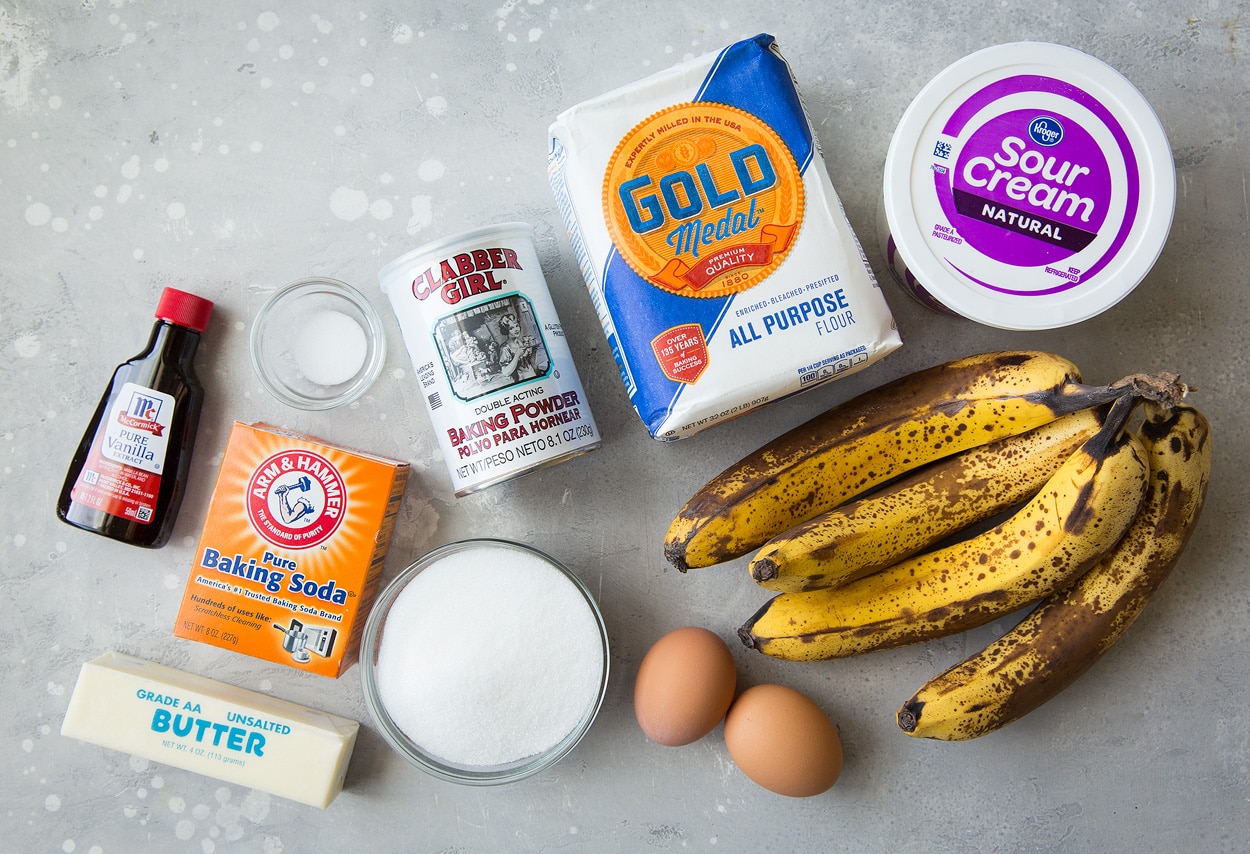 This is the best banana bread recipe! Quick and easy to make and no mixer is required. It's perfectly moist and amazingly tender and it's brimming with banana flavor. Simply put, everyone will have a hard time stopping at just one slice! #cookingclassy #banana #bread #bananabread homemade banana bread ingredients on a gray surface