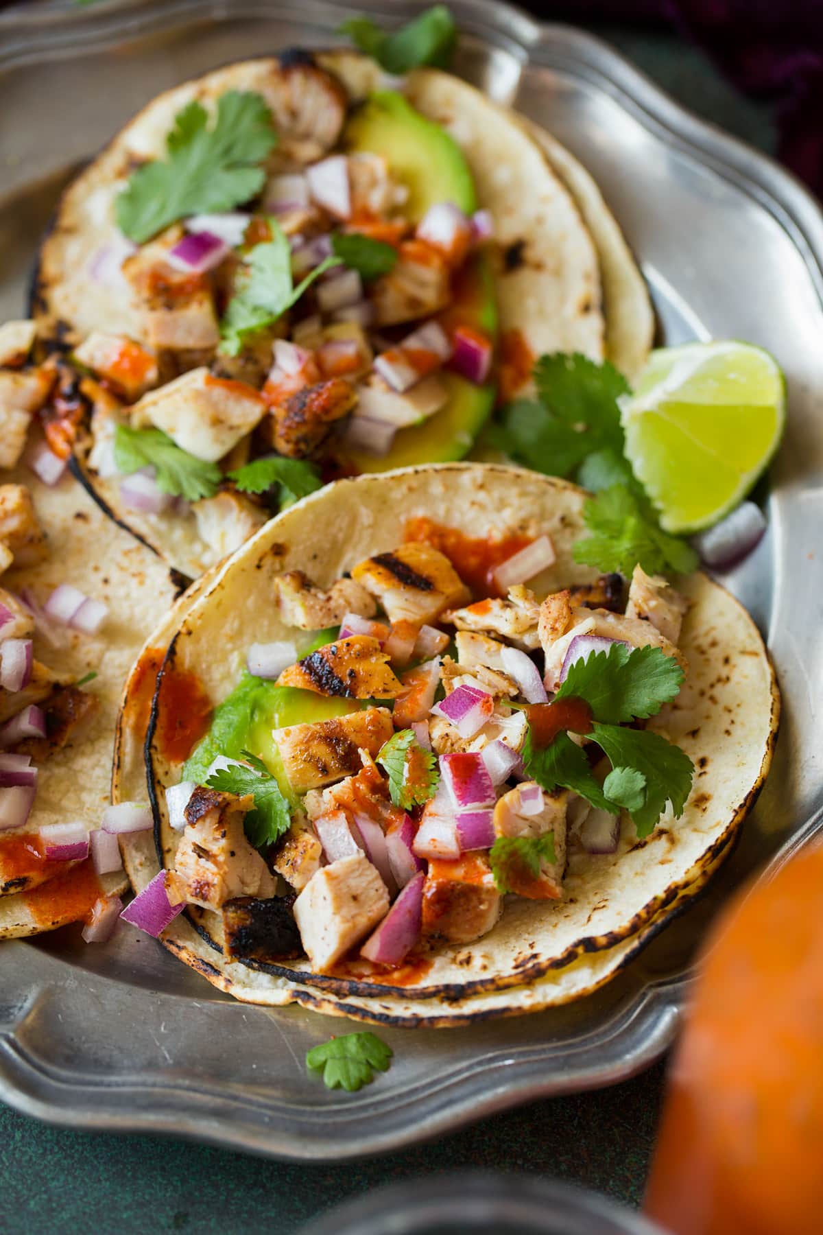 Grilled Chicken Street Tacos Close up image of chicken street tacos shown laying open on a serving plate.