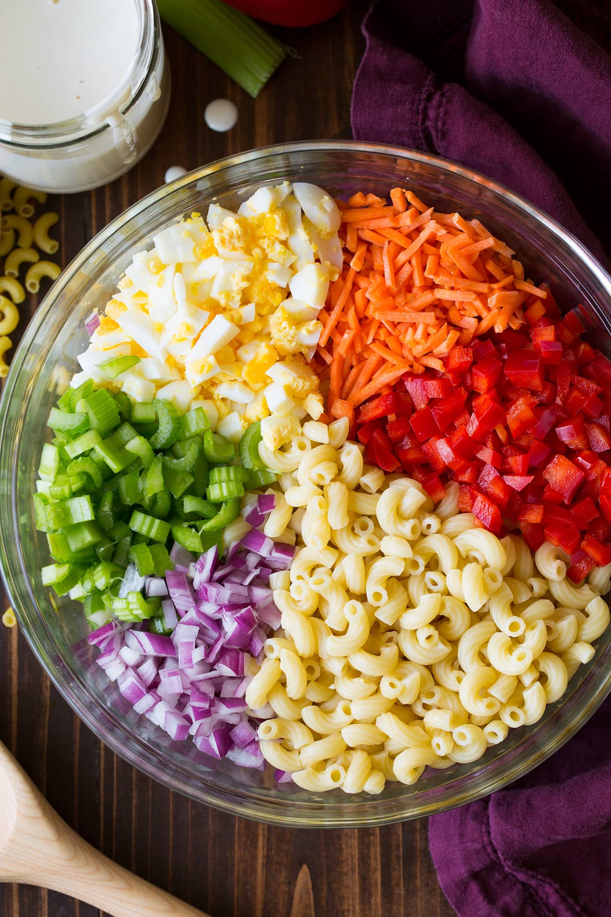 Macaroni Salad Macaroni salad ingredients in a glass bowl before tossing together.