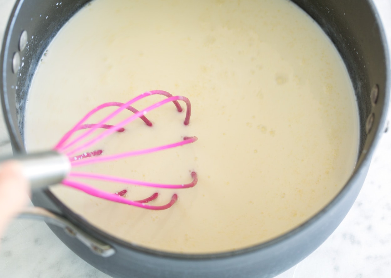 Mac and Cheese adding milk to mixture in saucepan