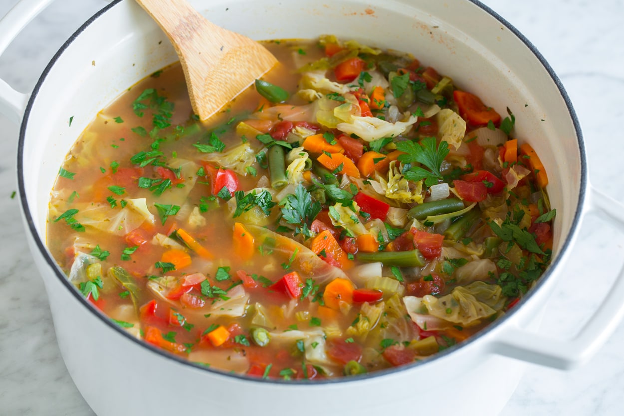 https://active-metabolism.news/chicken-noodle-soup-2/ Cabbage Soup shown after finished cooking in large white pot.
