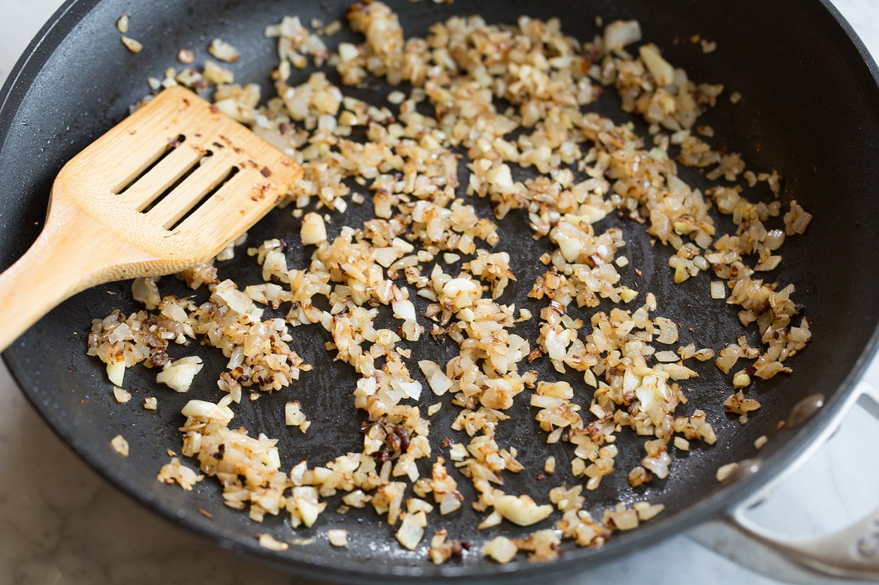 Homemade Spaghetti Sauce Sauteing onion and garlic in dark skillet for easy spaghetti sauce