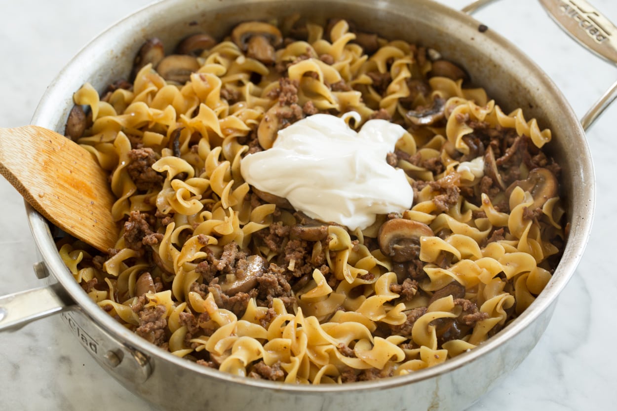 Beef Stroganoff Adding sour cream to beef stroganoff in saute pan