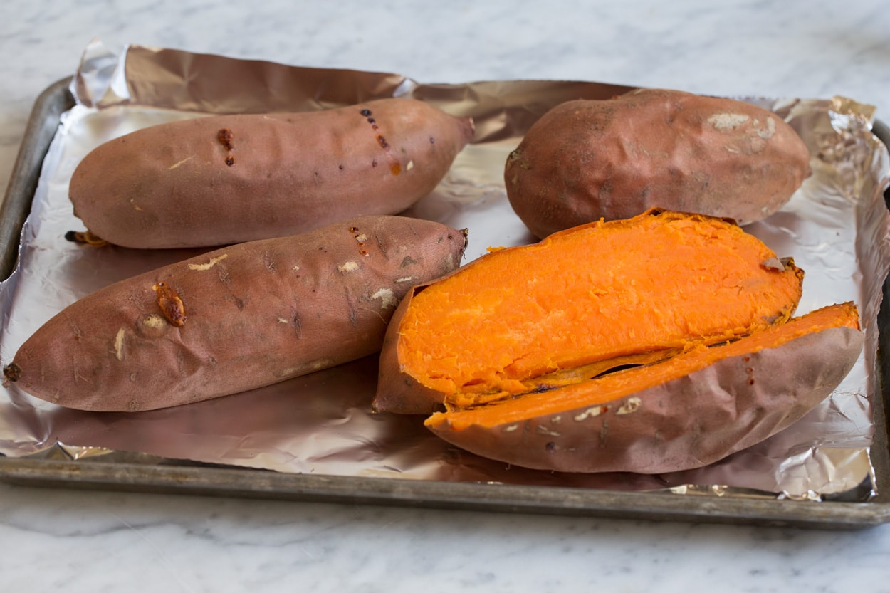 Sweet Potato Casserole Four baked sweet potatoes shown here, one sliced open. Before adding to sweet potato casserole.
