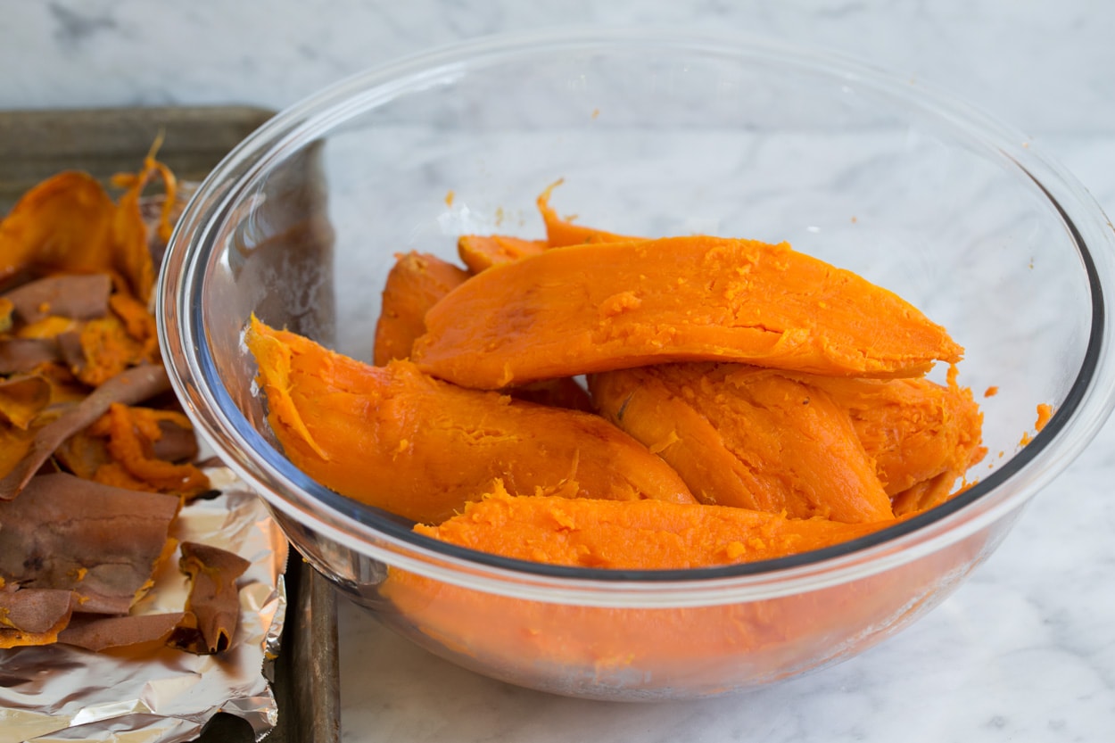 Sweet Potato Casserole Sweet potatoes in a large glass mixing bowl to make sweet potato casserole.